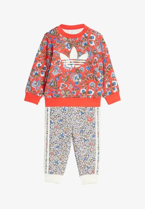 Red floral sweatshirt featuring white logo, paired with white floral patterned pants and side stripes. Both garments have ribbed cuffs.