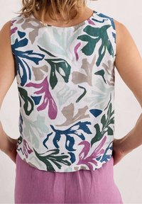 Top senza maniche in lino con un motivo di foglie colorate in verde, blu, rosa e beige su sfondo bianco; colletto rotondo e vestibilità corta.