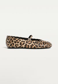Ballet flats kuosia leo, jotka on muotoiltu pyöreäksi varpaaksi, litteällä mustalla pohjalla ja pienellä hihnalla, jossa on hopeinen yksityiskohta. Valmistettu sileästä materiaalista.