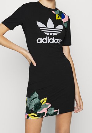 Czarna sukienka Adidas z krótkim rękawem, dużym białym logo oraz kolorowymi zielonymi, żółtymi, różowymi i niebieskimi kwiatowymi nadrukami na ramieniu i na dole.