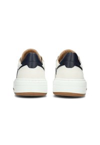 Witte leren sneakers met marineblauwe accenten, voorzien van een dikke witte zool en een gestructureerde bruine rubberen zool. De achterkant benadrukt de ontwerpdetails.