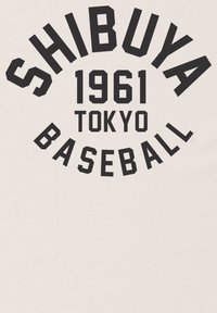 Bílá tkanina s výrazným černým textem. Design zahrnuje "SHIBUYA," "1961," "TOKYO" a "BASEBALL" uspořádané do kruhu.