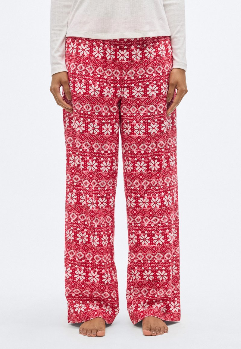 Pantalon de détente rouge à motifs avec des dessins floraux et géométriques blancs, fabriqué en tissu doux avec une coupe ample et une taille élastique.