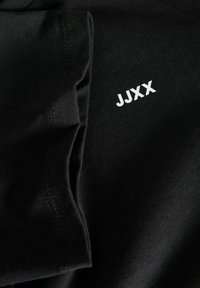 Svart bomull T-skjorte med hvit "JJXX" logo på brystet, glatt tekstur, standard passform og sydd detaljer på sømmene.