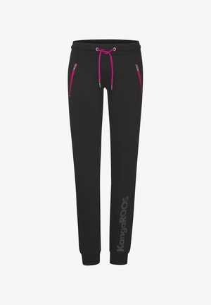 Black sweatpants made of soft fabric feature pink accents, two zippered pockets, and a drawstring waistband. Logo printed on the leg.
