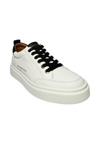 Sneakers bianchi in pelle con lacci neri, collo imbottito e accenti neri a contrasto. Marchio dorato sul lato, suola in gomma, design testurizzato.