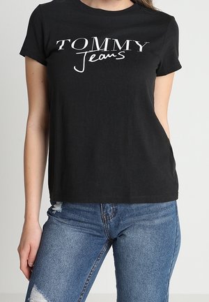 Czarny bawełniany t-shirt z wyrazistym, białym logo "TOMMY Jeans". Krótkie rękawy i okrągły dekolt. W komplecie z niebieskimi, postarzanymi dżinsami.