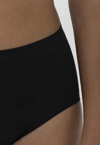 Schwarze high-waisted Unterwäsche aus glattem Stoff, mit einem schlichten Design und nahtlosem Rand für mehr Komfort und ein elegantes Erscheinungsbild.