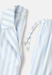 Conjunto de pijama a rayas en azul claro y blanco que presenta un cuello y detalles de botones en la parte superior, con lazos ajustables en la cinturilla elástica de los pantalones.