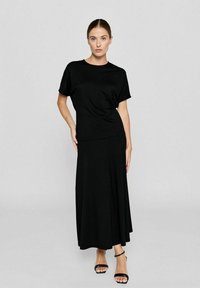 Schwarzes Kleid mit kurzen Ärmeln, tailliertem Oberteil und fließendem Rock. Hergestellt aus glattem, elastischem Stoff. Minimalistisches Design ohne sichtbare Muster.
