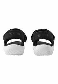 Svarta sandaler med en strukturerad, vit gummisula. Justerbara remmar med "reima"-logotyp. Enkel, öppen design för ventilation.