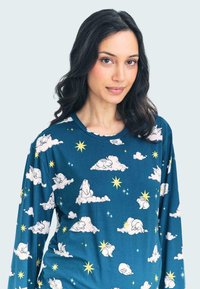 Long-sleeve top in teal fabric featuring white clouds, bunnies, and yellow stars in a repeating pattern. Soft texture and relaxed fit.