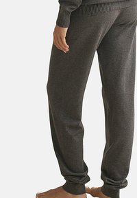 Donkergrijze joggerbroek gemaakt van een zachte, gestructureerde stof. Heeft een relaxte pasvorm met elastische enkels en een ribgebreide tailleband.