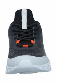 Schwarze Sportschuhe mit strukturiertem Mesh-Obermaterial, weißen Akzenten, orangefarbenen Details und einer gepolsterten weißen Sohle mit traditionellen Schnürsenkeln.