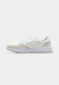 Lacoste sneakers featuring a mix of white leather and light gray suede, a textured midsole, and a rugged rubber outsole, with laces.