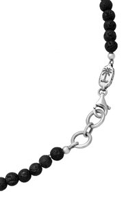 Black lava bead necklace featuring a silver chain and clasp, detailing a palm tree emblem on the centerpiece.