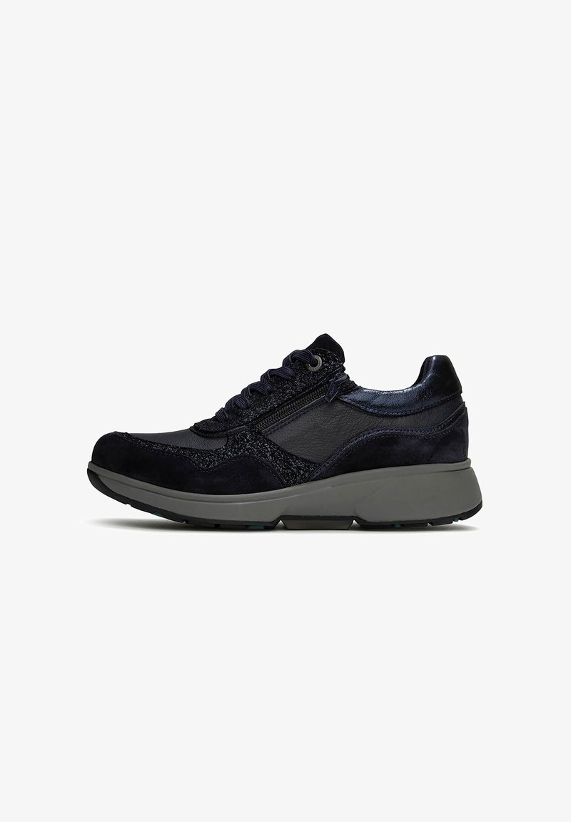 Zwarte leren en stoffen sneaker met veters aan de voorkant, een ritssluiting aan de zijkant en dikke grijze zool.