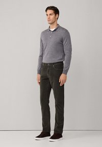 Grijze longsleeve polo met een klassieke kraag, gecombineerd met donkergroene corduroy broek en bruine sneakers. Heeft een slim-fit ontwerp.