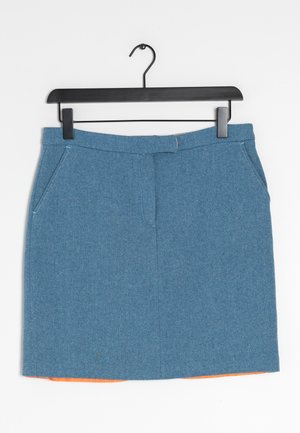 Sininen teksturoitu minihame, jossa on sivutaskut, roikkuu mustalla ripustimella, oranssi vuori hieman näkyvissä alahelmassa.