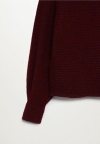 Burgundi värvi kudum, millel on tekstuuriline muster, laiad mansetid ja lõdva istuvusega, esitleb pehmet ja mugavat materjali.