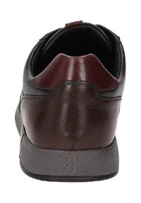 Braunes Leder-Schuhwerk mit glatter Textur, runder Ferse und kontrastierenden burgunderfarbenen Akzenten auf der Rückseite. Gummisohle mit strukturiertem Finish.