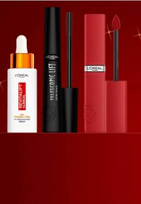 Produits de beauté L'Oréal Paris sur fond rouge : un sérum blanc avec des accents orange, un mascara noir et une couleur à lèvres liquide rouge en finition mate.