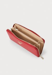Red leather wallet with a textured finish, zip closure, multiple compartments, and a beige interior featuring a zippered pocket.