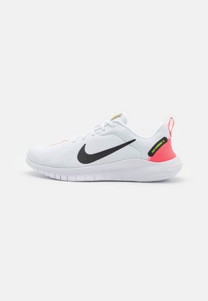 Hvid Nike løbesko med sort Swoosh, pink hælflip og fleksibel hvid sål, vist fra ydersiden.