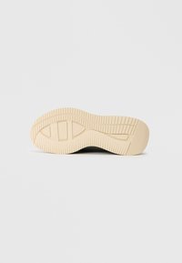 Semelle de sneaker avec une surface en caoutchouc crème texturé, présentant des rainures et des motifs pour l'adhérence, conçue pour la traction et la durabilité.