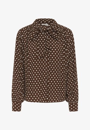 Blusa marrone a maniche lunghe con pois bianchi, chiusura frontale con bottoni e fiocco annodato al collo.