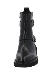 Botín de cuero negro hasta el tobillo con dos correas ajustables y hebillas de metal, puntera redondeada, suela texturizada y diseño de tacón bajo.