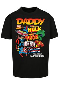 Black cotton t-shirt featuring colorful superhero graphics and text. Design includes characters like Spider-Man, Hulk, and Thor with playful phrases.