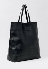 Sac fourre-tout en cuir noir de forme rectangulaire, présentant un motif texturé et deux anses plates pour le transport.