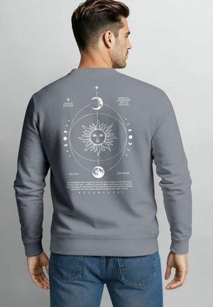 Grauer Sweatshirt mit weißen, himmelischen Grafiken, darunter Sonne, Mond und Text. Baumwollmaterial mit gerippten Bündchen und Saum.