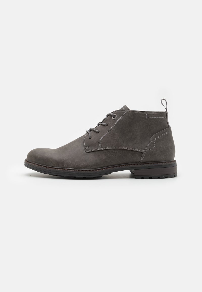 Bottes de cheville en cuir gris avec une texture lisse, bout rond, couture contrastante et une languette au talon. Semelle en caoutchouc pour une meilleure adhérence.