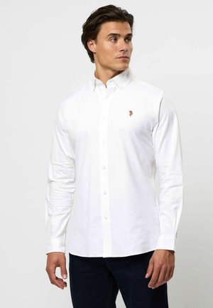 Biała, długosleeve koszula zapinana na guziki z klasycznym kołnierzykiem, z małym haftowanym logo na piersi. Gładka bawełniana tkanina, dopasowany krój.