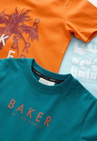 Trys marškiniai: oranžinis su palmės medžio detalėmis, žydras su raudonu užrašu "BAKER" ir šviesiai mėlynas fonas su palmės siluetais. Medvilnė.