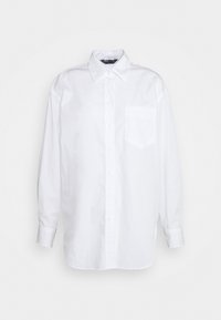 Camicia bianca a maniche lunghe in cotone con colletto abbottonato, taschino sul petto e chiusura frontale con bottoni. Tessuto liscio.