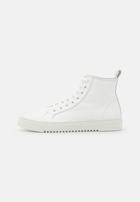 Sneakers bianche alte in pelle liscia, con chiusura frontale con lacci, suola in gomma testurizzata e un anello sul retro per una calzata facile.