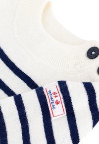 Maglione a maglia crema con righe orizzontali blu navy, con scollo rotondo e due bottoni neri. Include un'etichetta cucita sull'orlo.