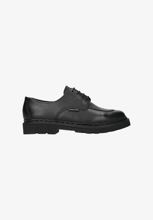 Chaussure habillée en cuir noir avec finition texturée, bout arrondi, six œillets et semelle en caoutchouc épaisse avec un motif de bande de roulement visible.