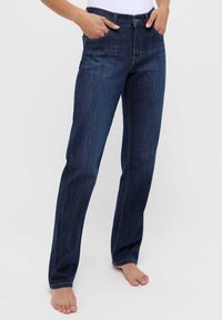 Jeans de denim azul oscuro y de pierna recta. Cuentan con un cierre de botón, cinco bolsillos y costuras visibles para un detalle adicional.