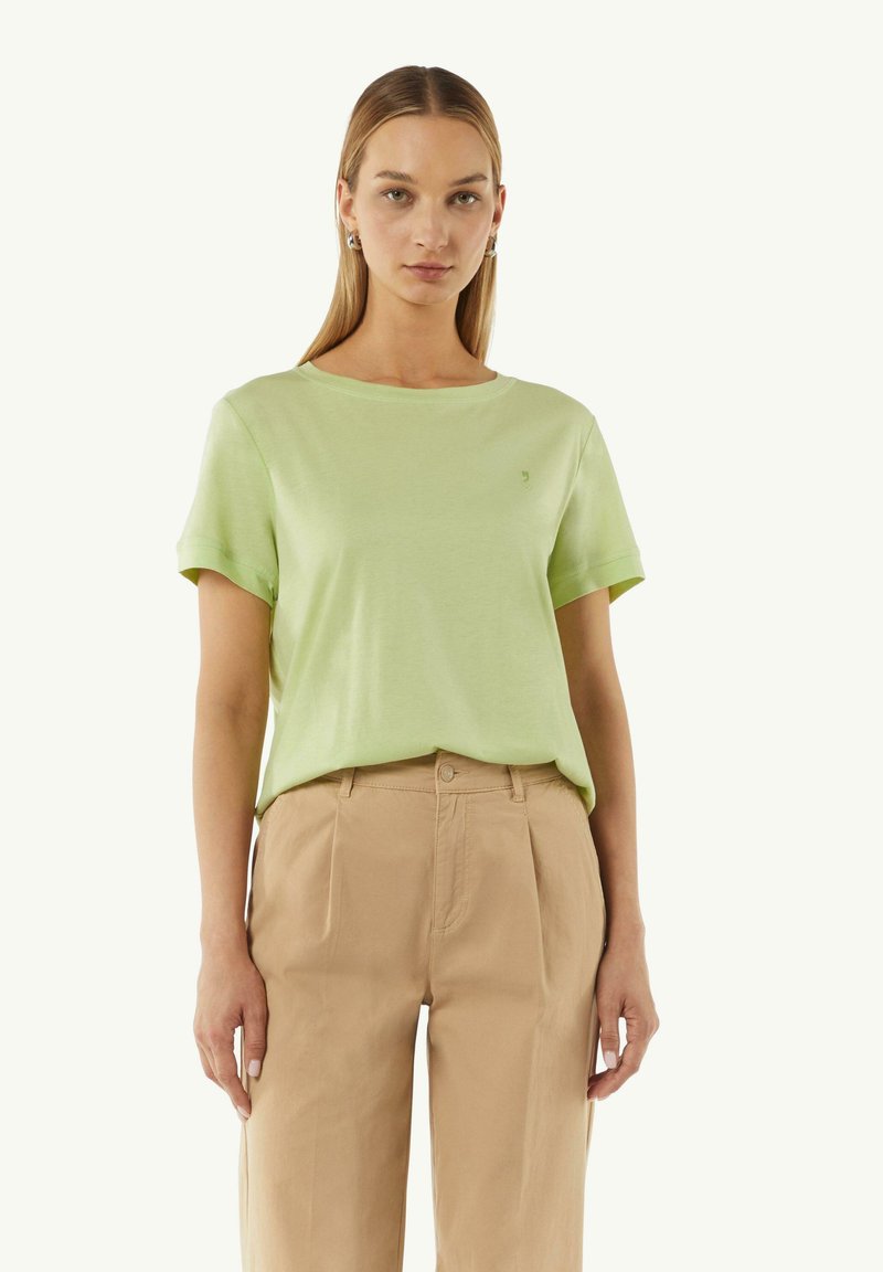 Lichtgroene t-shirt met korte mouwen en een ronde hals, met een subtiele logo op de borst, gecombineerd met beige hoge taille broeken.