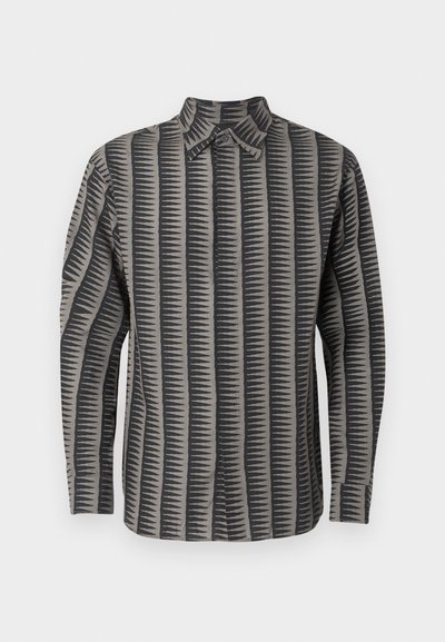 Ilgos rankovės marškiniai su sagomis, pilkos ir juodos vertikalios zigzago juostelės raštu ir smailiais apykakle ant balto fono.