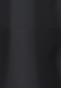 Tissu noir avec une couture horizontale créant deux sections de textures distinctes, la partie supérieure plus lisse que la partie inférieure à tissage plus grossier.