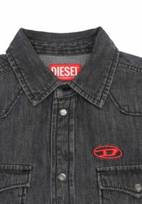 Camicia in denim nera con colletto a punta, bottoni a pressione argentati e logo ricamato rosso sulla tasca sinistra del petto.