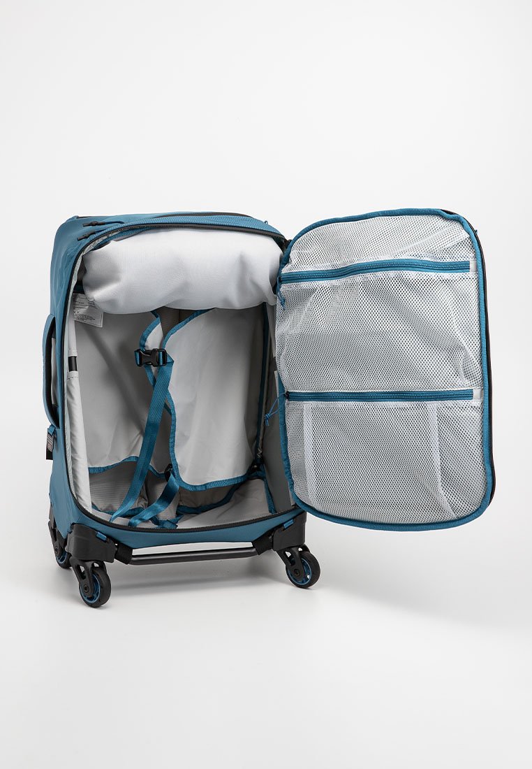 Blauer weicher Koffer mit vier Rädern, geöffnet um ein leeres Inneres zu zeigen, verstellbare Riemen und einzipbare Netzfächer an der Innenseite des Deckels.