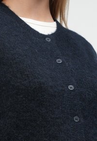 Μπλε ναυτικό ζακέτα από υλικό με υφή, με στρογγυλή λαιμόκοψη, έξι μαύρα κουμπιά και υφασμένο μοτίβο.