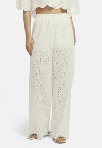 Witte wijde broekspijpen van lichtgewicht stof met een oogjesontwerp. Voorzien van een elastische tailleband en twee zijzakken.