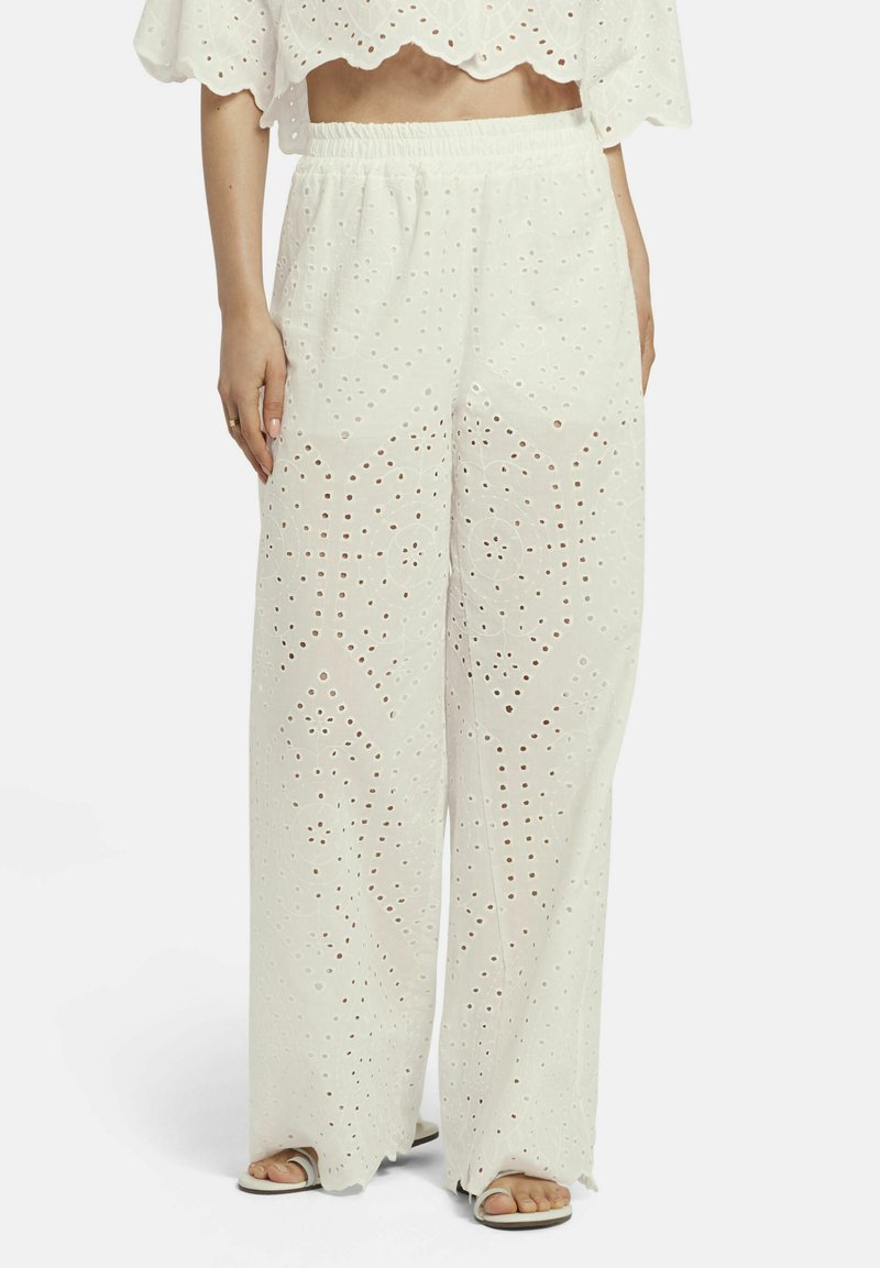 Witte wijde broekspijpen van lichtgewicht stof met een oogjesontwerp. Voorzien van een elastische tailleband en twee zijzakken.
